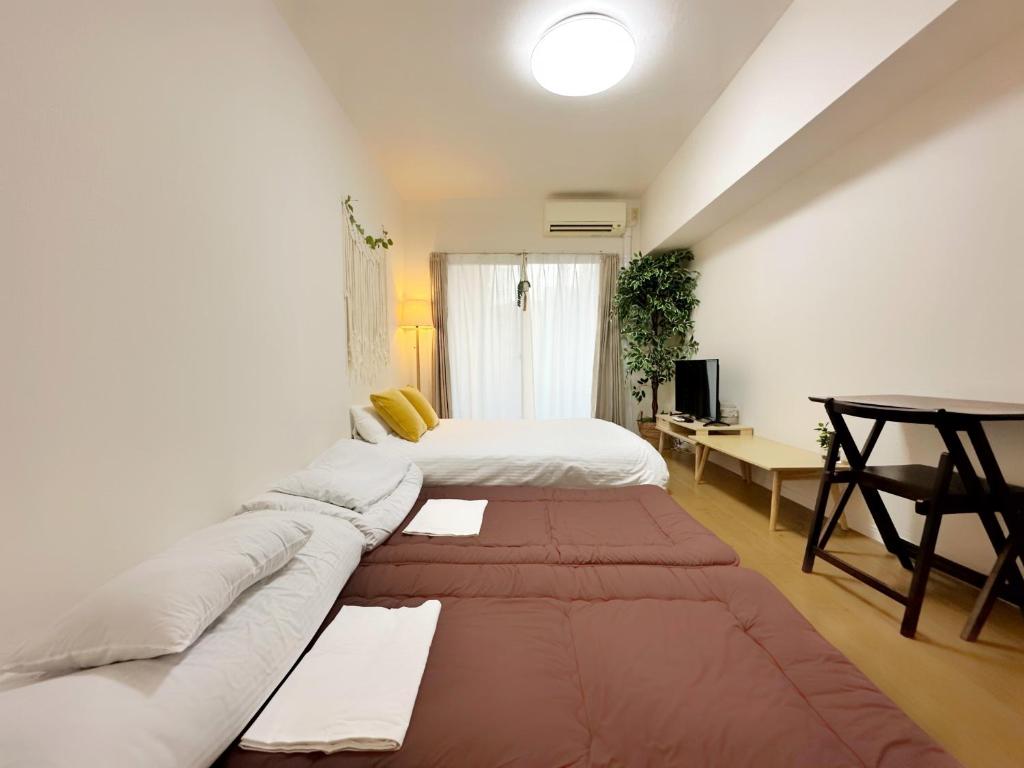 a living room with a couch and a bed at Picolo Hakata in Fukuoka