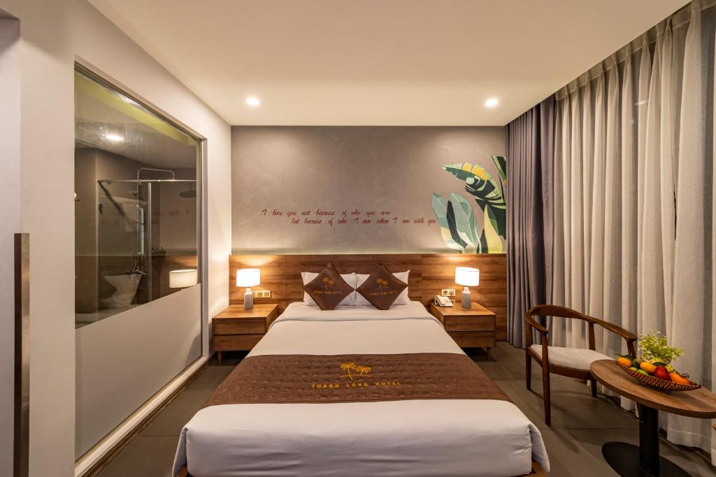 Habitación de hotel con 2 camas, mesa y silla en Thanh Long Hotel - Tra Khuc en Ho Chi Minh