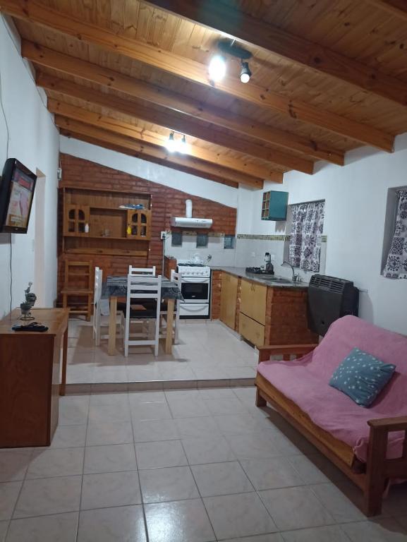 eine Küche und ein Wohnzimmer mit einem Sofa und einem Tisch in der Unterkunft Lo de Nelly in Puerto Madryn