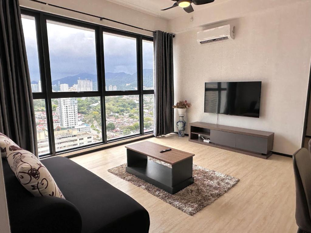a living room with a couch and a tv at Urban Pleasure Suites Central of GeorgeTown Jelutong in Jelutong