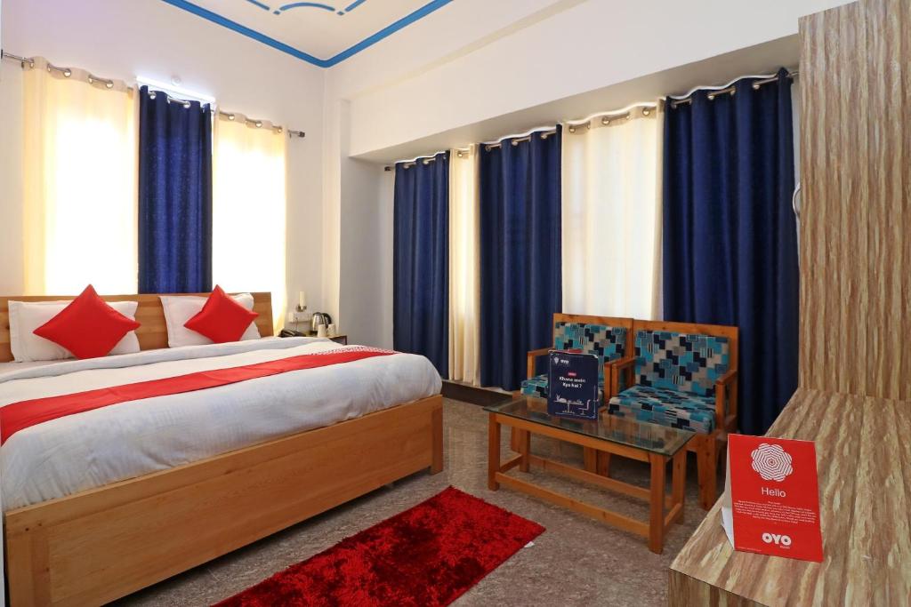 a bedroom with a bed and a table and a chair at OYO Flagship Hotel Ratnodaya in Almora