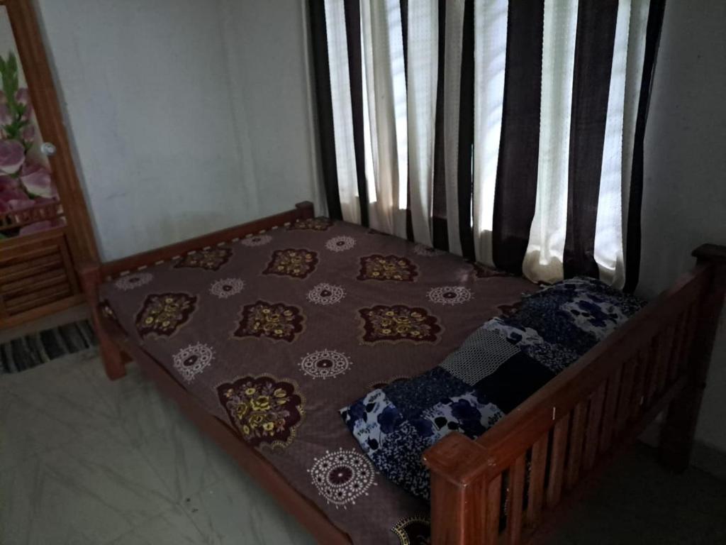 1 cama pequeña con edredón y almohadas en Apple Hotel Rooms, en Vagamon