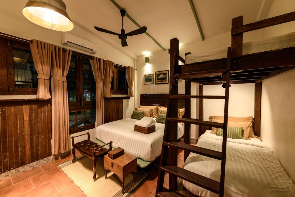 a bedroom with two bunk beds and a window at Hanuman Boutique Stay &Eatery in Hat Yai