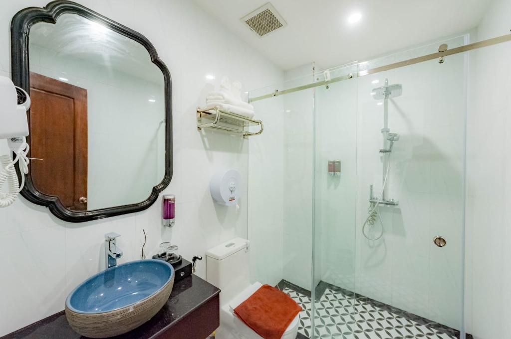 a bathroom with a sink and a shower with a mirror at Cozy An Boutique Hotel Luangprabang in Luang Prabang
