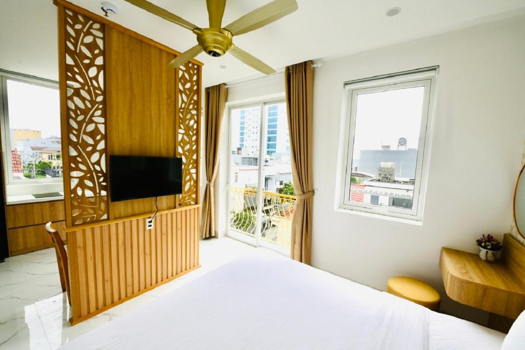1 dormitorio con 1 cama y TV de pantalla plana en Le's Apartment & Coffee, en Da Nang