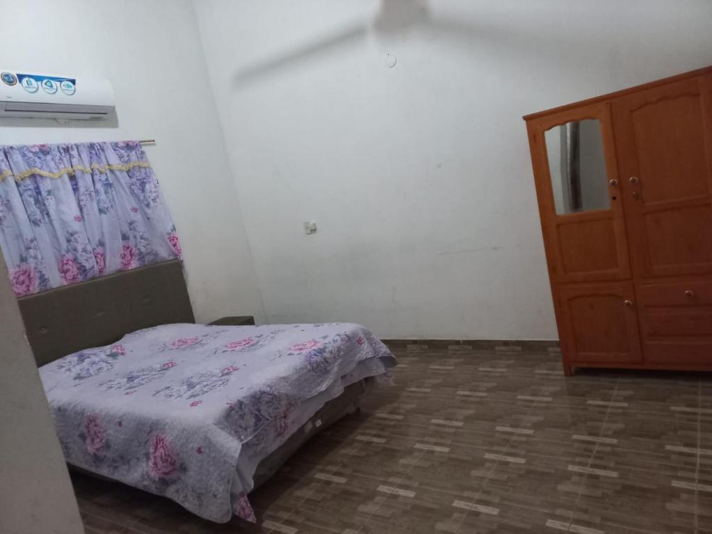 een kleine slaapkamer met een bed en een dressoir bij HOSPEDAJE 3 de Mayo in Encarnación