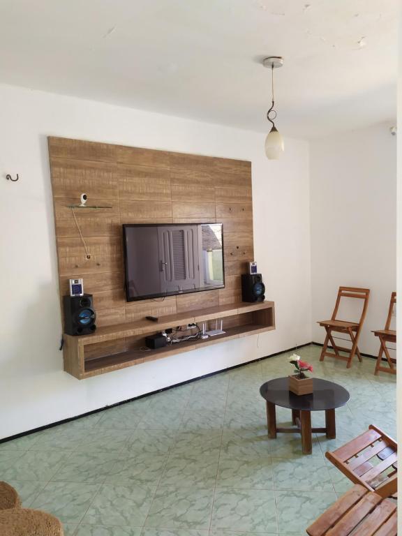 a living room with a flat screen tv on a wall at Casa de praia in Luis Correia