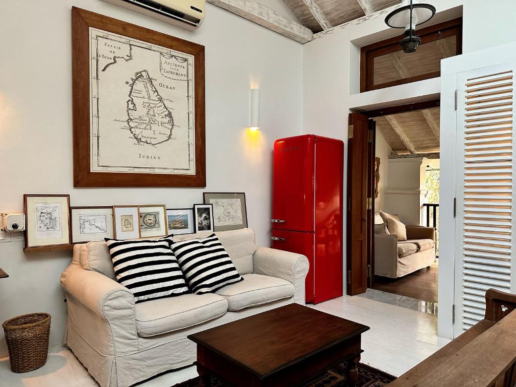 ein Wohnzimmer mit einem Sofa und einem roten Kühlschrank in der Unterkunft 1A Court Square by AQUA Villa in Galle