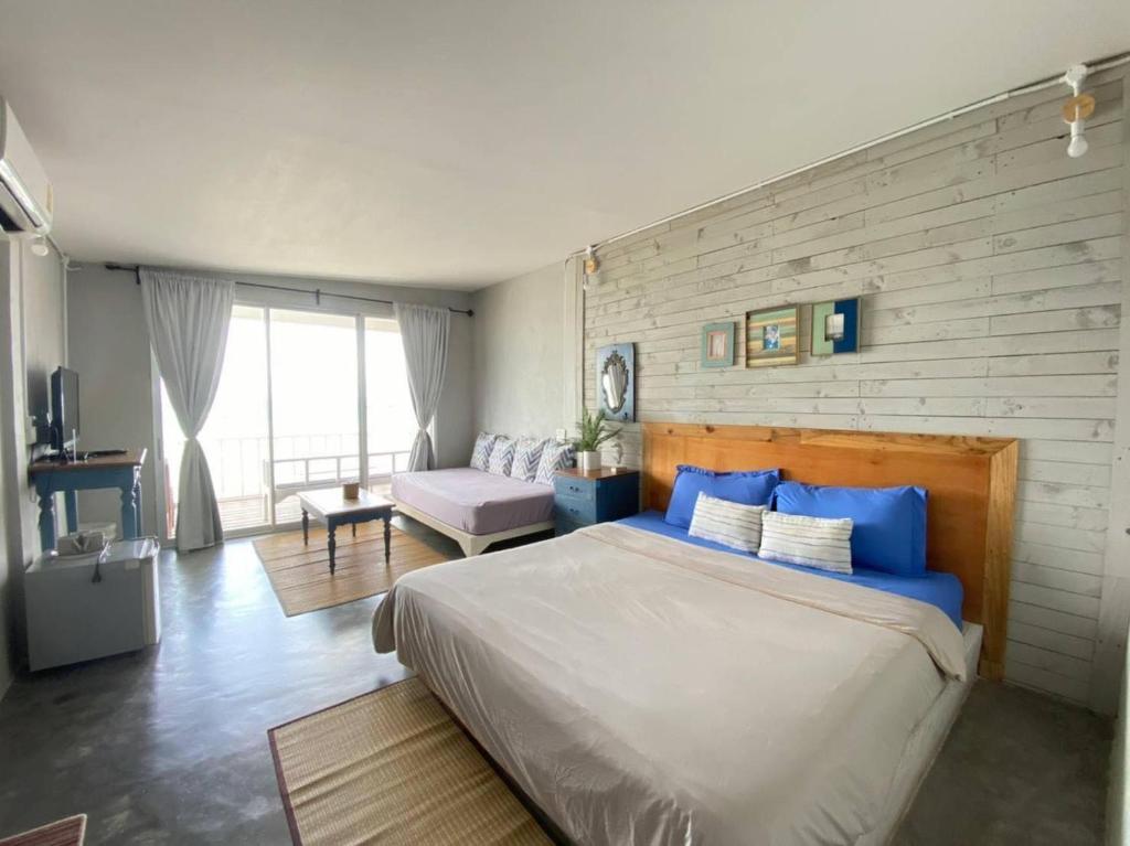 a bedroom with a large bed and a couch at บ้านฟ้าใส รีสอร์ท เกาะล้าน in Ko Larn