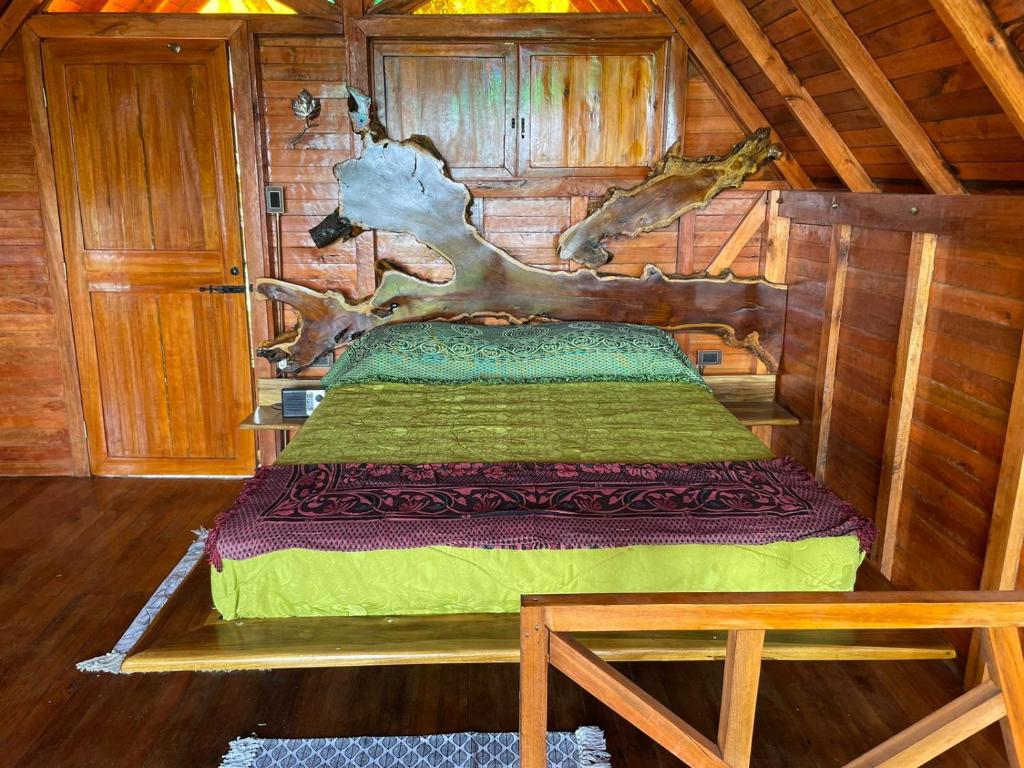 a bedroom with a bed in a log cabin at Cabañas la Miranda in Filandia