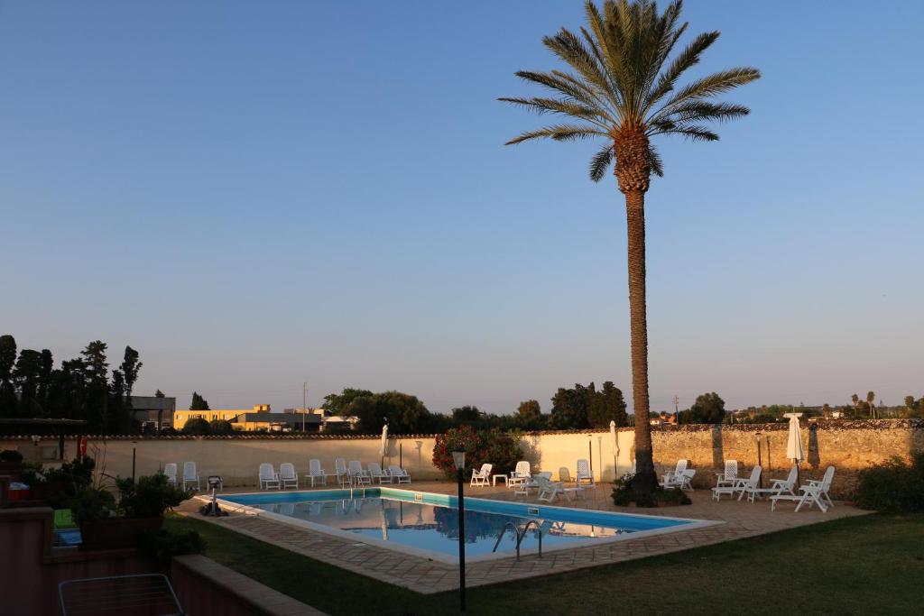 una palmera y una piscina con una palmera en Antica Gebbia en Siracusa