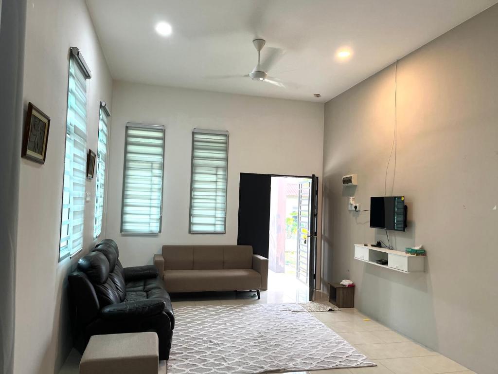 a living room with a couch and a tv at Homestay Ashad in Kuantan