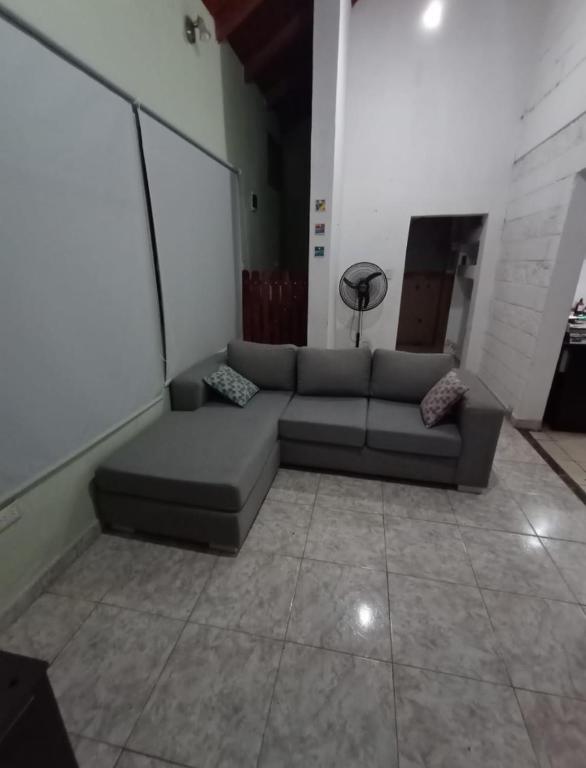 ein Wohnzimmer mit einem Sofa in einem Zimmer in der Unterkunft Casa para el festival in Colonia Caroya