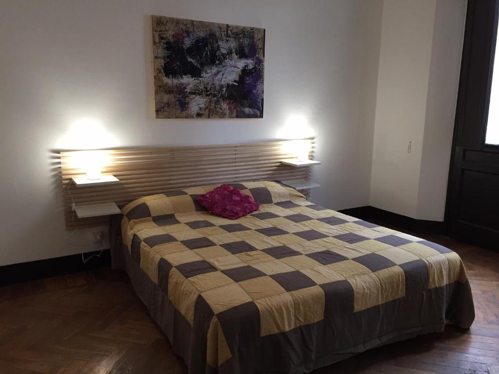 a bedroom with a bed with a checkered blanket at B & B 21 Bologna in Bologna