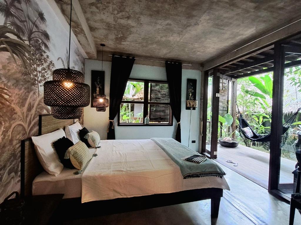 a bedroom with a bed and a large window at La Plage Hotel in El Nido