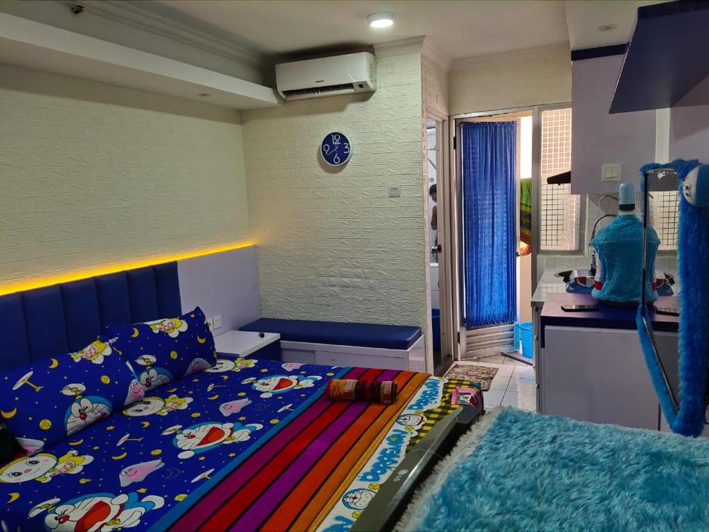 a bedroom with a bed with a blue head board at Apartemen Kalibata City By Diamond Property in Jakarta