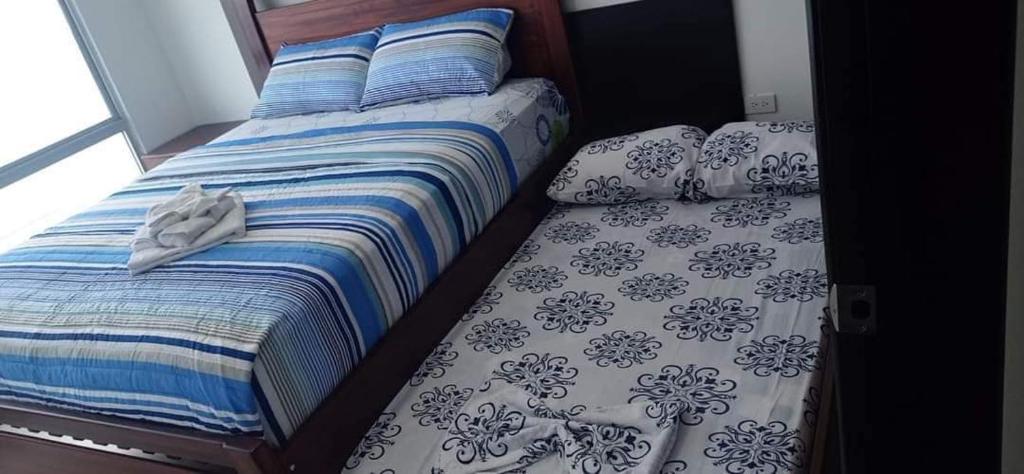 Schlafzimmer mit einem Bett mit Kissen und Kissen in der Unterkunft Deymar_ tonsupa in Tonsupa
