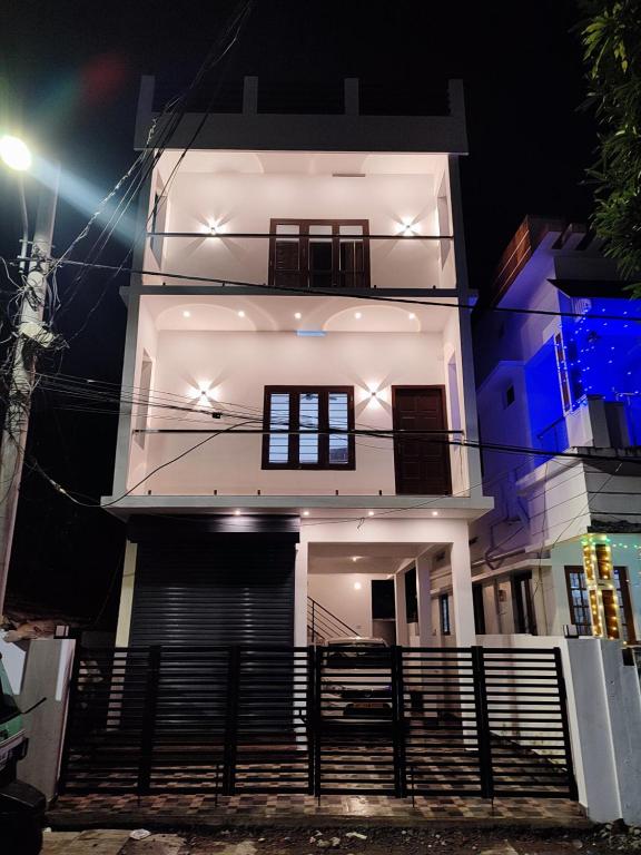 uma casa branca à noite com luzes em Alam Home Stay em Cochin