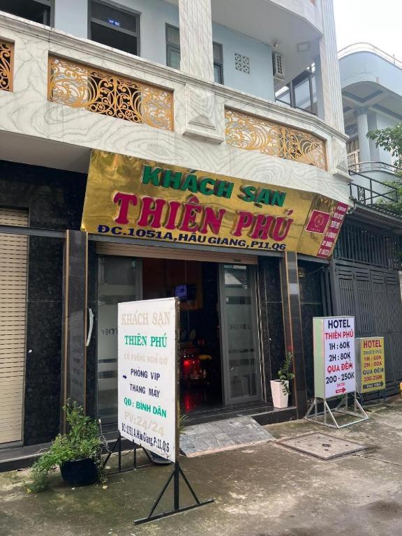 een winkel met borden voor een gebouw bij Khách Sạn Thiên Phú in Ho Chi Minh-stad