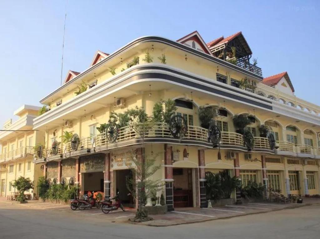 a large yellow building with plants on the balconies at Keanthay Guest House in Battambang