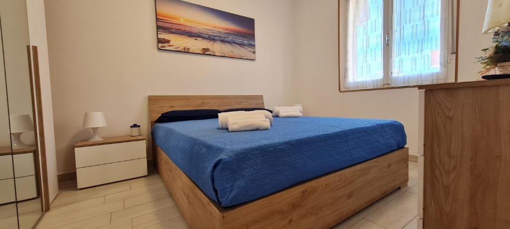 1 dormitorio con cama con sábanas azules y ventana en Aedes Residenza Lido - 80 mt dalla spiaggia - self check-in en Alghero