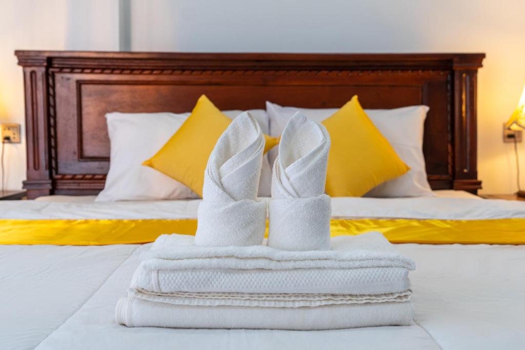 a pair of white shoes on a pile of towels on a bed at The Khmer house Villas in Siem Reap