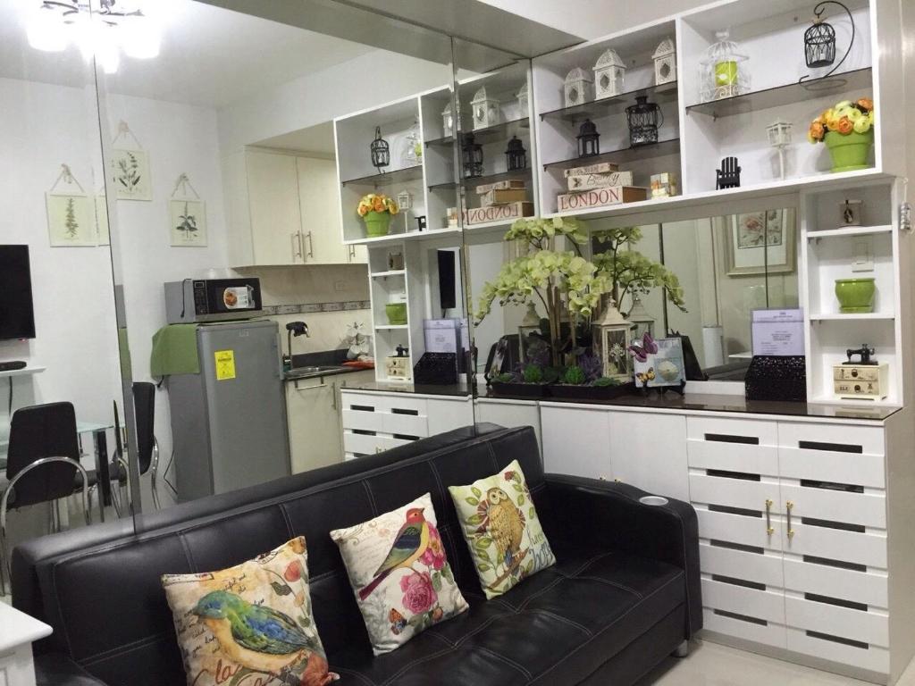 a living room with a couch and a kitchen at Sea Residences MoA Manila in Manila