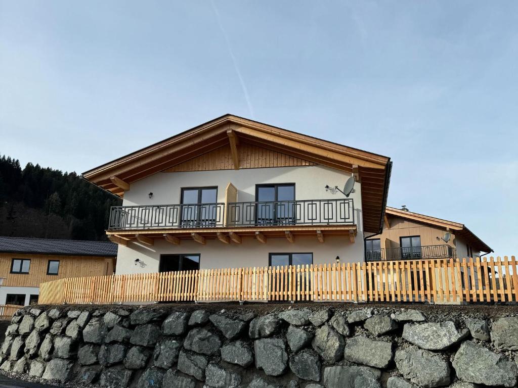 une maison avec un balcon au-dessus d'un mur en pierre dans l'établissement Chalet near Nassfeld ski resort in Carinthia, à Hermagor