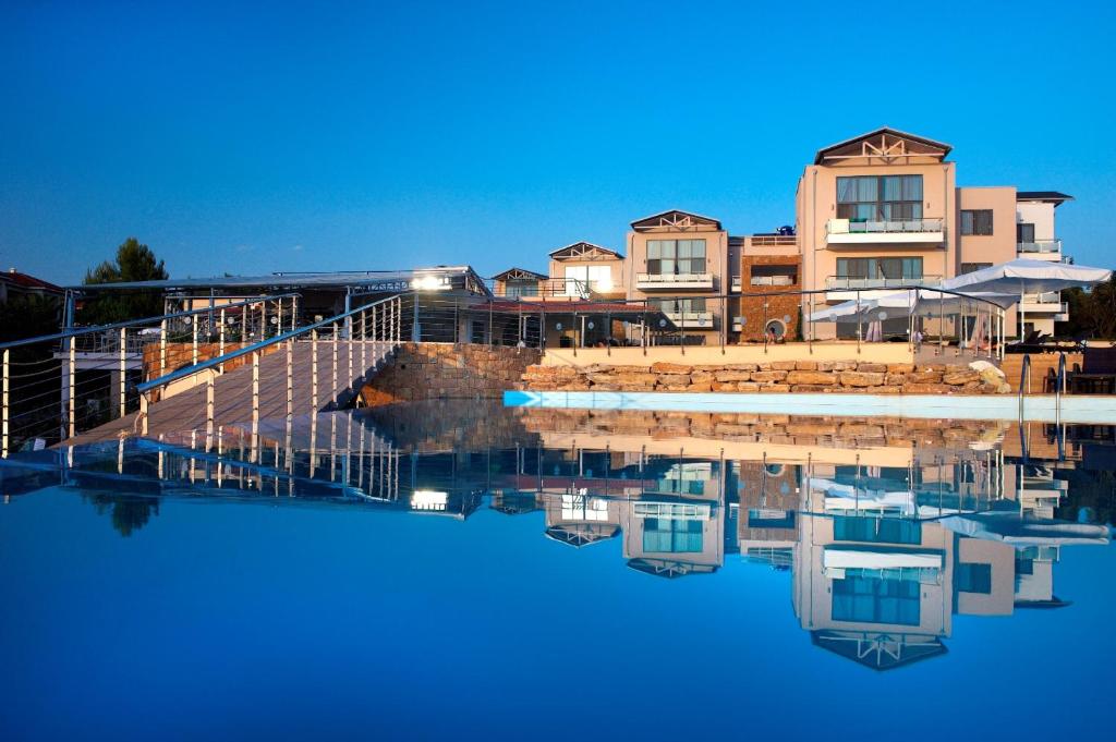 a reflection of a building in a body of water at Istion Club & Spa in Nea Potidaea