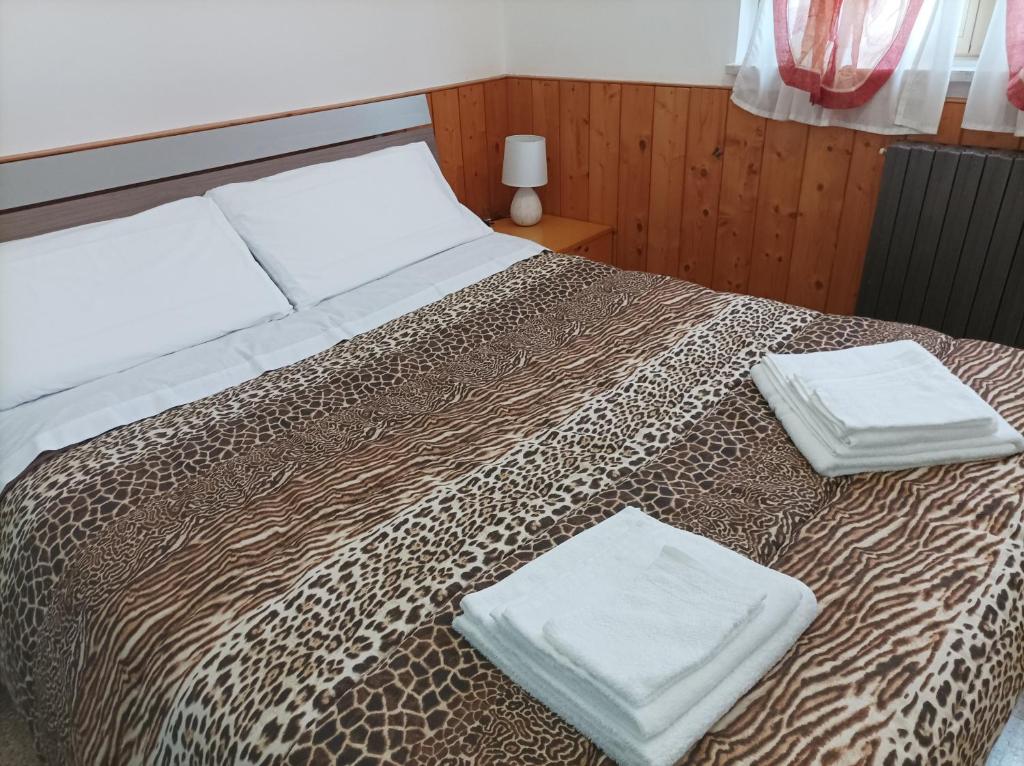 Una cama con dos toallas blancas encima. en Affitta camere Via Piave, en Foligno