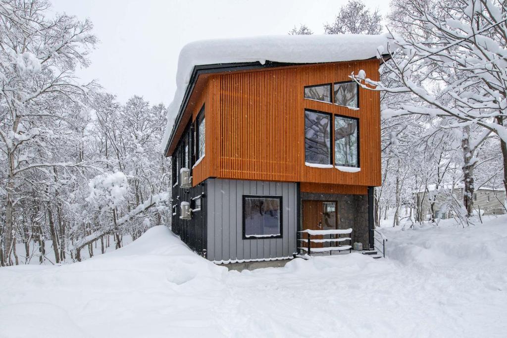 a small cabin in the snow in the woods at Moraine Onsen Chalet in Niseko