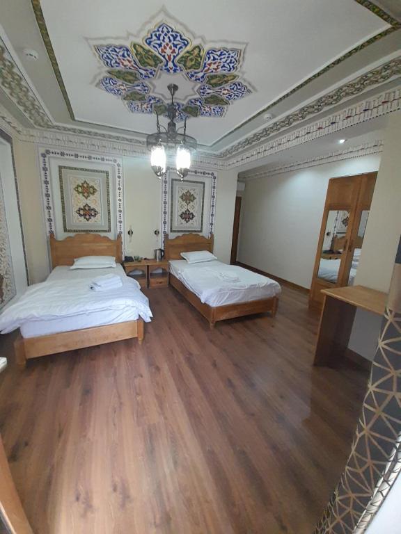 a large room with two beds and a chandelier at Amina Hotel boutique in Bukhara