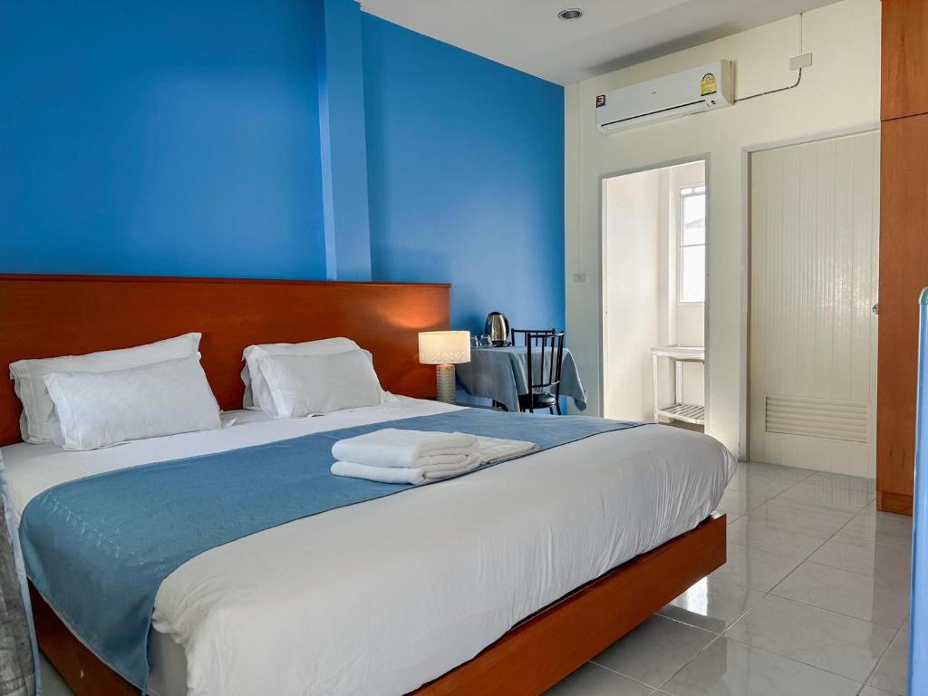 um quarto com uma parede azul e uma cama em Grandma Kaew House em Chiang Rai