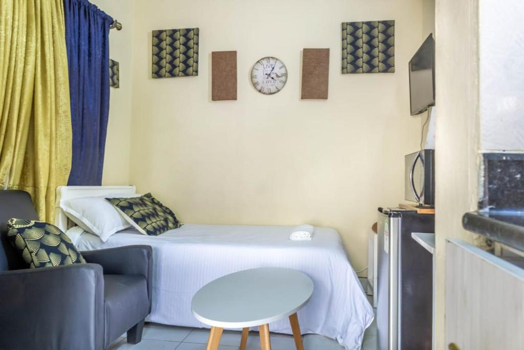 a small room with a bed and a table at T's Place in Nairobi