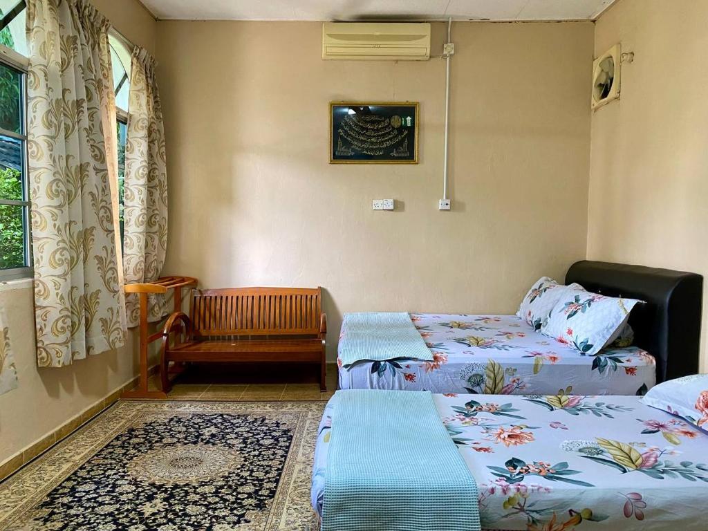 a room with two beds and a chair at COZY GL Roomstay ARAU in Kangar