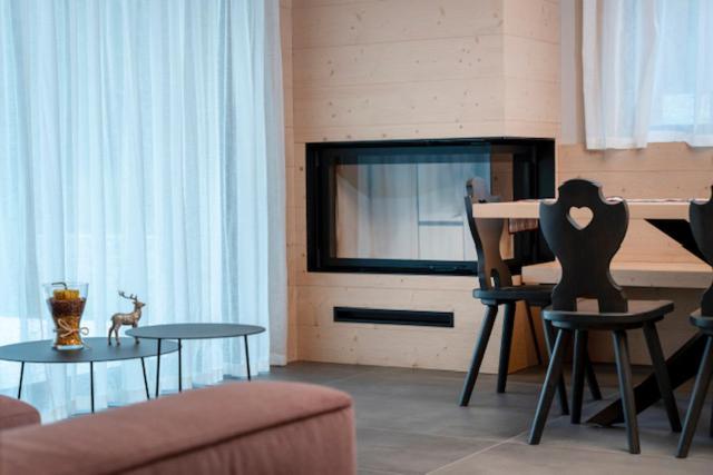 - un salon avec un canapé, une table et un piano dans l'établissement Kile Alpine Resort, à Valbruna