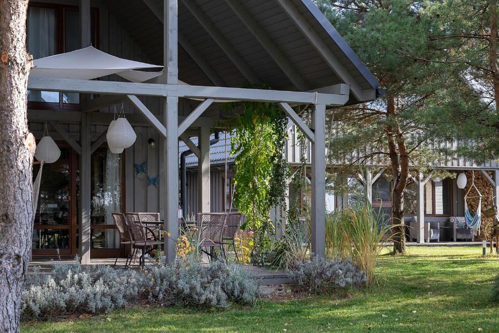 a porch of a house with chairs and trees at Sirvis Apartamenty in Płaska