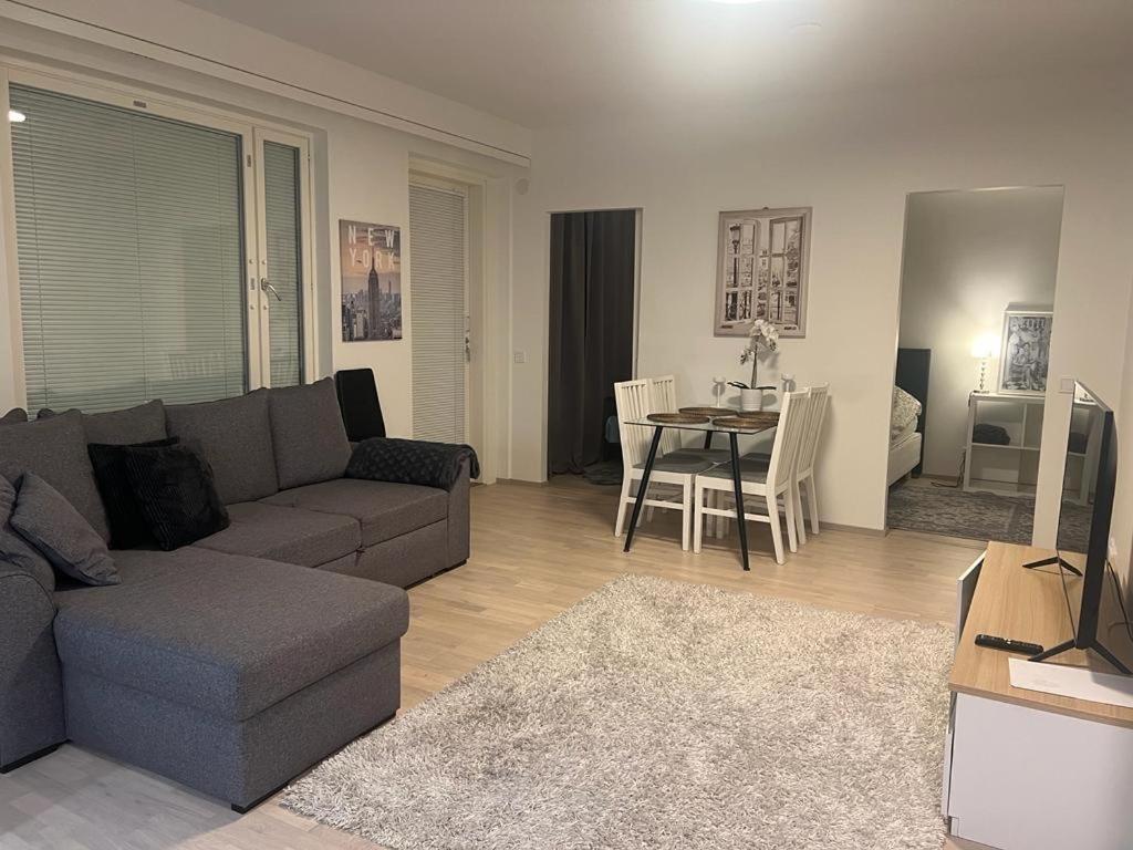a living room with a couch and a table at Modern city apartment with Sauna nearby the Airport in Vantaa