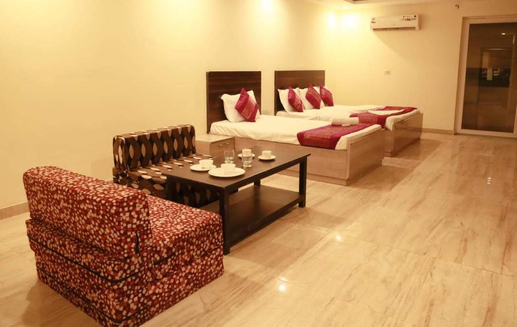 a living room with a bed and a couch and a table at Hotel Lakshmi Palace in New Delhi