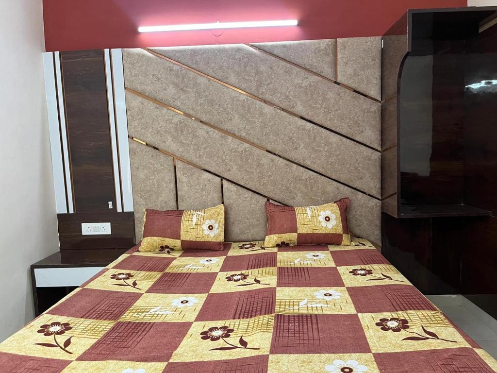 a bedroom with a bed with a quilt on it at Hotel Jyoti Deluxe in New Delhi