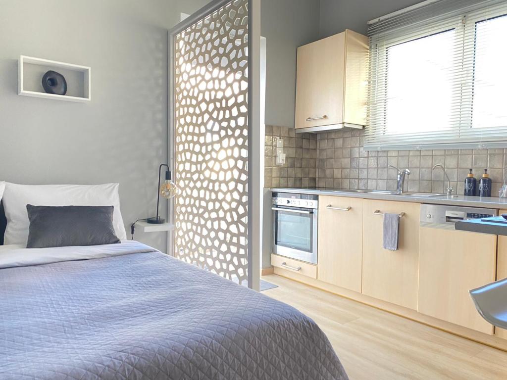 een slaapkamer met een bed en een keuken bij TINY LITTLE STUDIO in Athene
