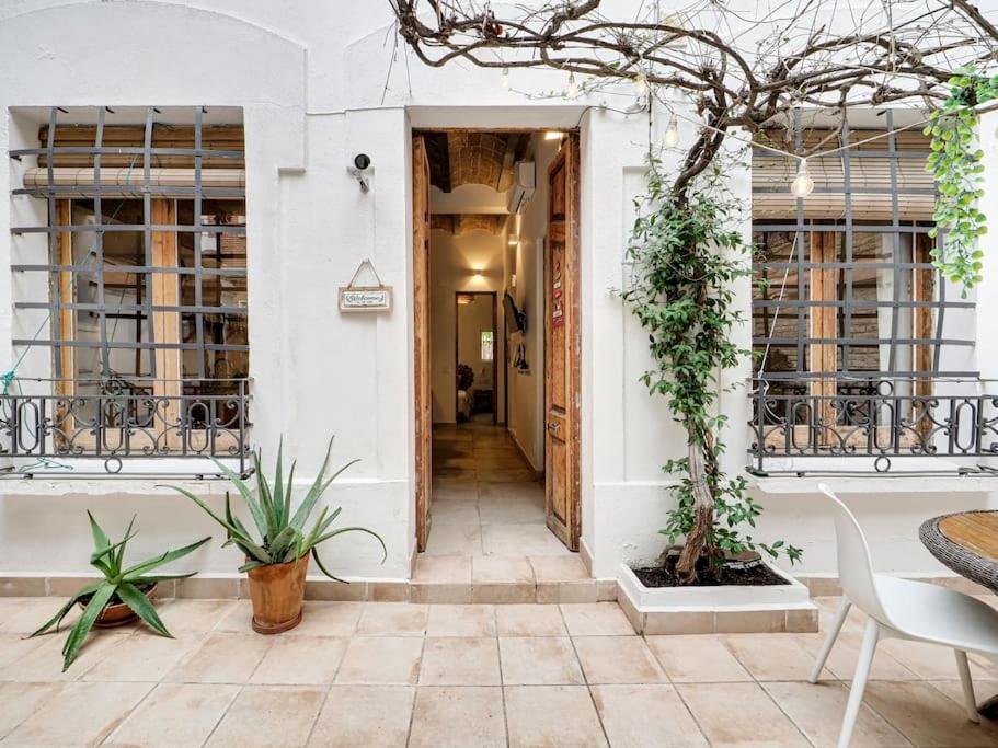 a hallway of a building with plants and a table at Casa Jasmin cosy 4 bedroom house with terrace in Hospitalet de Llobregat