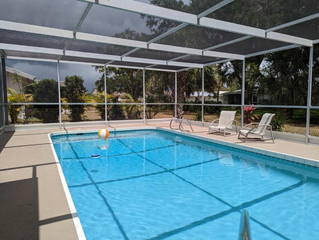 a large swimming pool with an umbrella over it at Vacation Home on Coral Sands in Venice