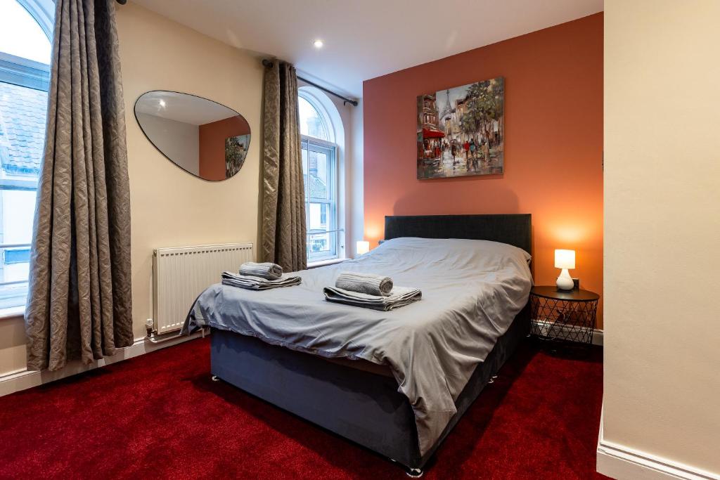 a bedroom with a bed and a large window at St Benedicts Apartments in Norwich