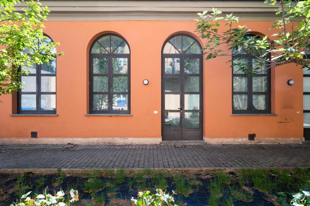 un bâtiment orange avec des fenêtres et une porte dans l'établissement Bigattera lofts - Affitti Brevi Italia, à Varèse