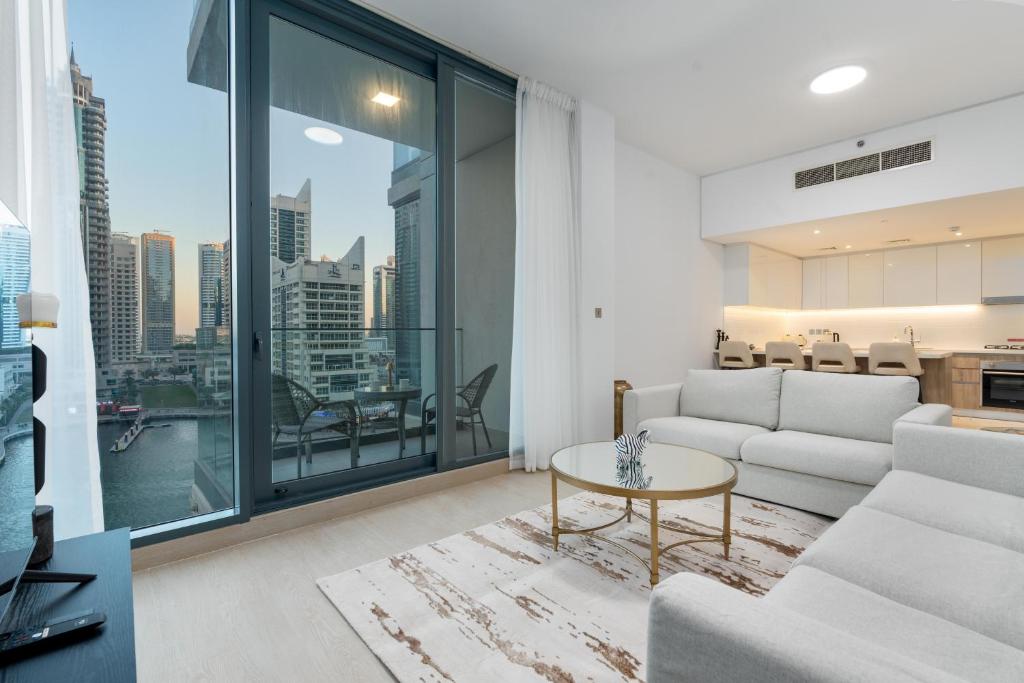 uma sala de estar com um sofá e uma mesa em ArbabHomes Lavish 2BR Dubai Marina View-LIV Residences em Dubai