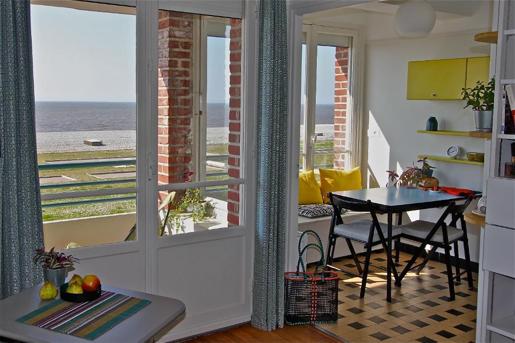a kitchen with a table and a view of the ocean at Le Continental in Cayeux-sur-Mer