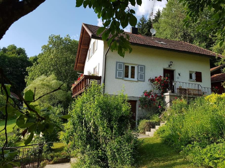 ein kleines weißes Haus mit einem Balkon und Bäumen in der Unterkunft Sonnwies - Erholung pur im Bayerischen Wald in Perlesreut