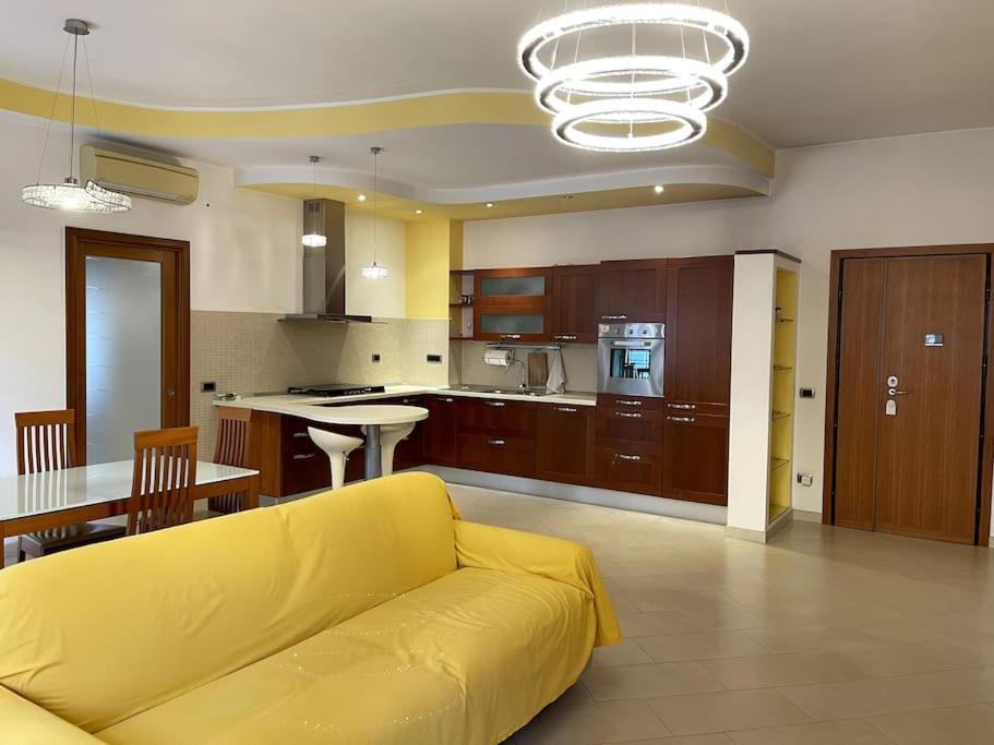 a living room with a yellow couch and a kitchen at Delizioso e silenzioso appartamento a Roma in Rome