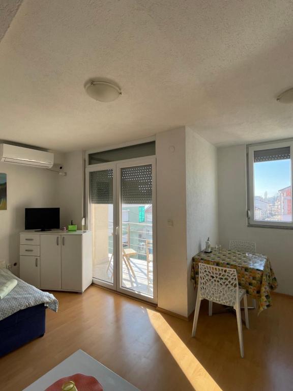 ein Wohnzimmer mit einem Tisch und einem Balkon in der Unterkunft Spirit Apartment 2 in Ohrid